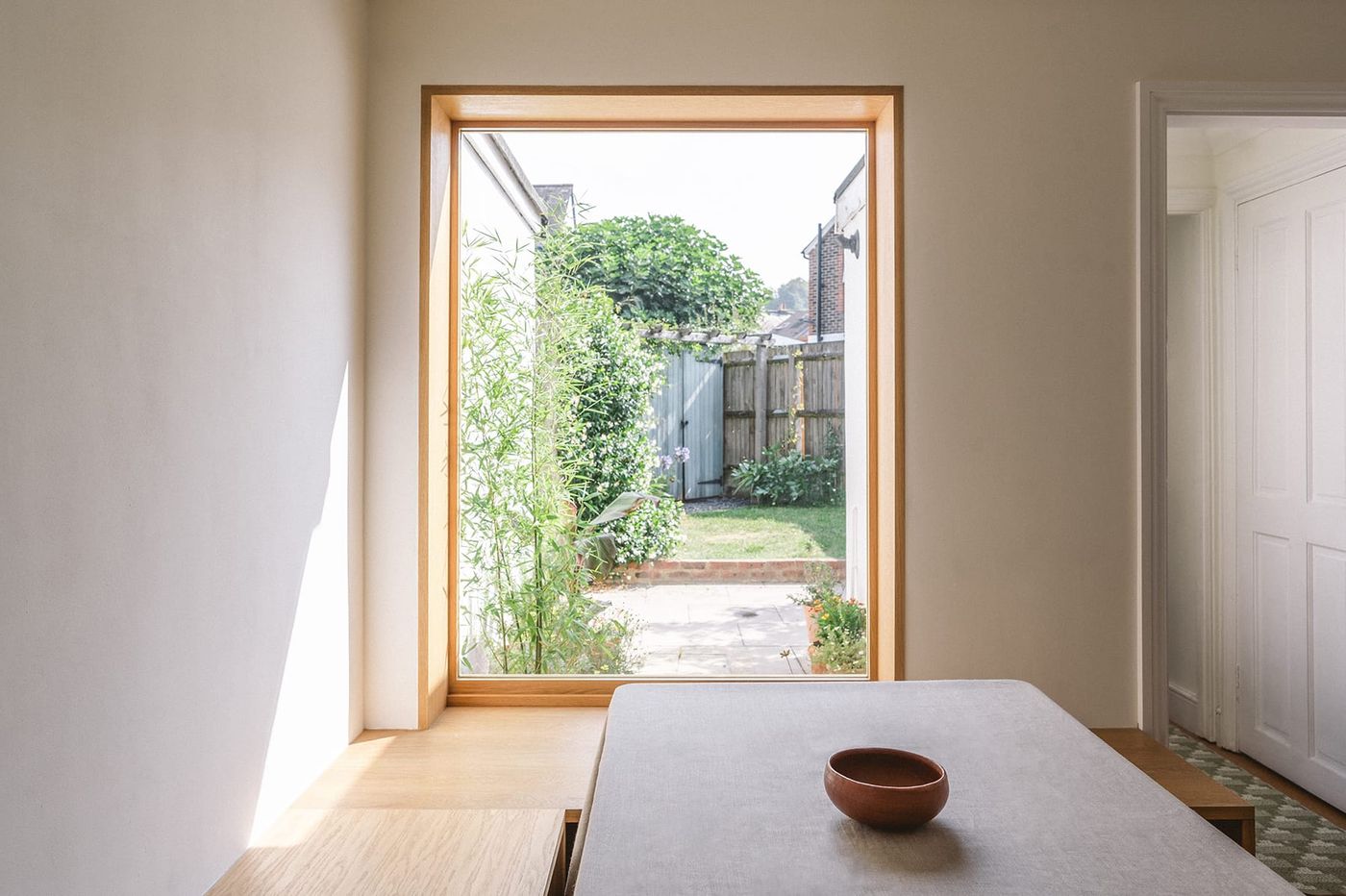 Internal view of the strong sunlight coming in through the oak framed timber kitchen window designed by From Works.