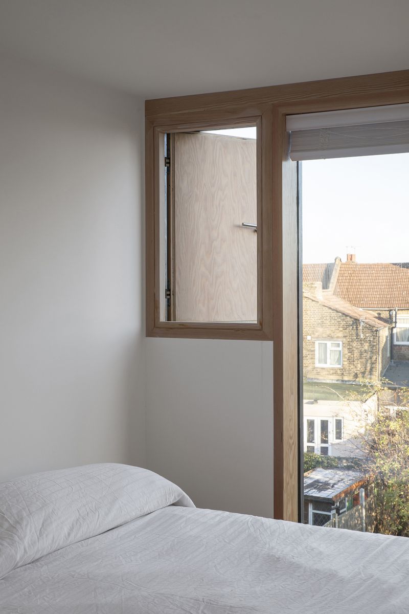 Interior view of the warm timber windows in the new master bedroom suite within From Works loft conversion and rear dormer extension in East London.